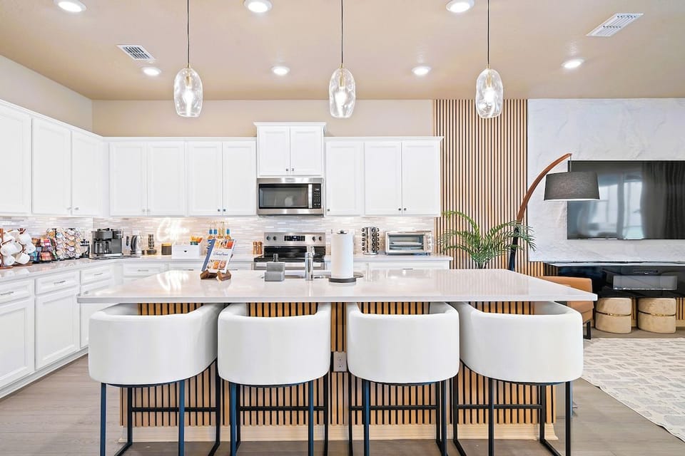Chef sized kitchen island with seating for four, pendant lighting and quartz counters.