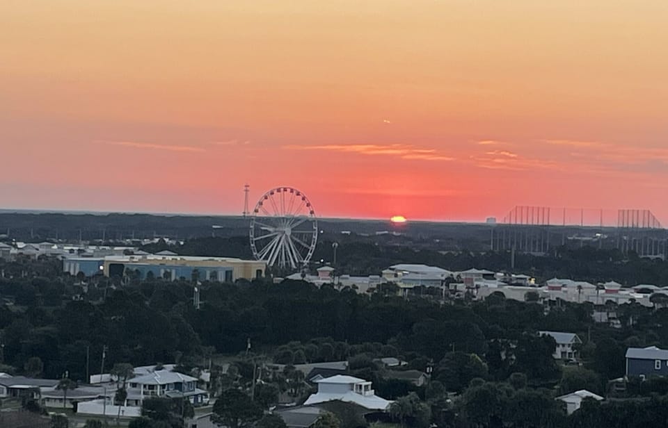 Sunrise over nearby Pier Park, glowing from your bright coastal living room