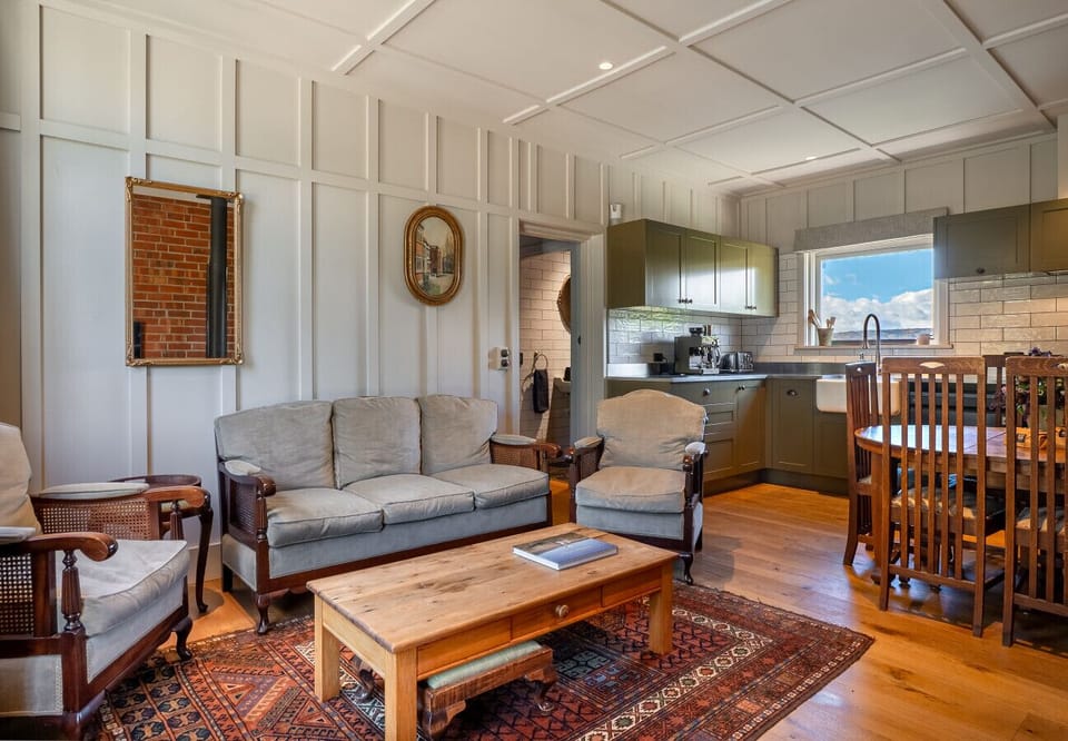 Light-filled lounge and kitchen space with original detailing and modern touches — perfect for sharing wine and stories after the day’s adventures