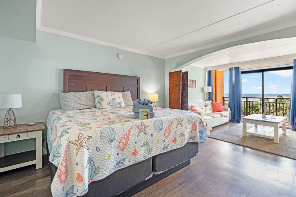 Spacious king bed dressed in bright coastal decor, a restful spot to unwind in this oceanview studio.