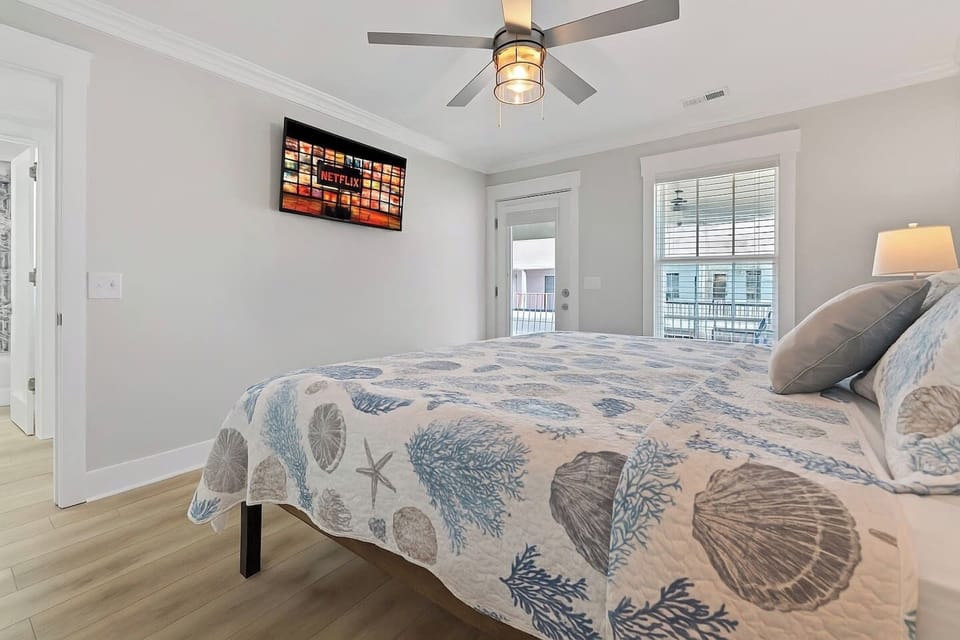 Spacious upstairs bedroom with smart TV and private veranda access.