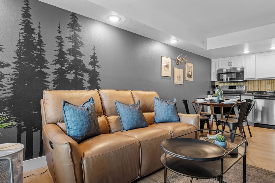 Relax in the stylish living room with leather sofas, accent pillows, and rustic décor, creating a cozy retreat after your Ozark adventures.