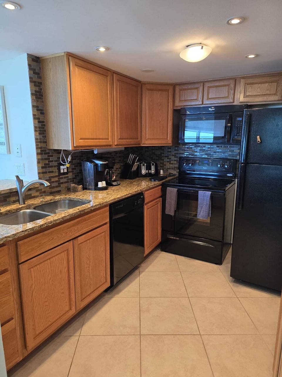Full kitchen with utensils and crockery.