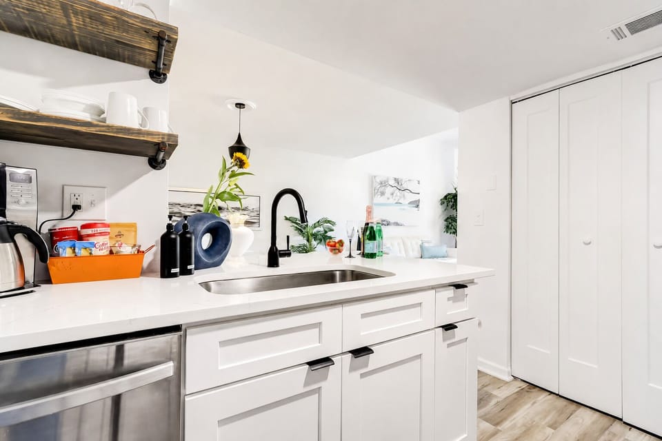 Bright modern kitchenette with sleek finishes and rustic open shelving