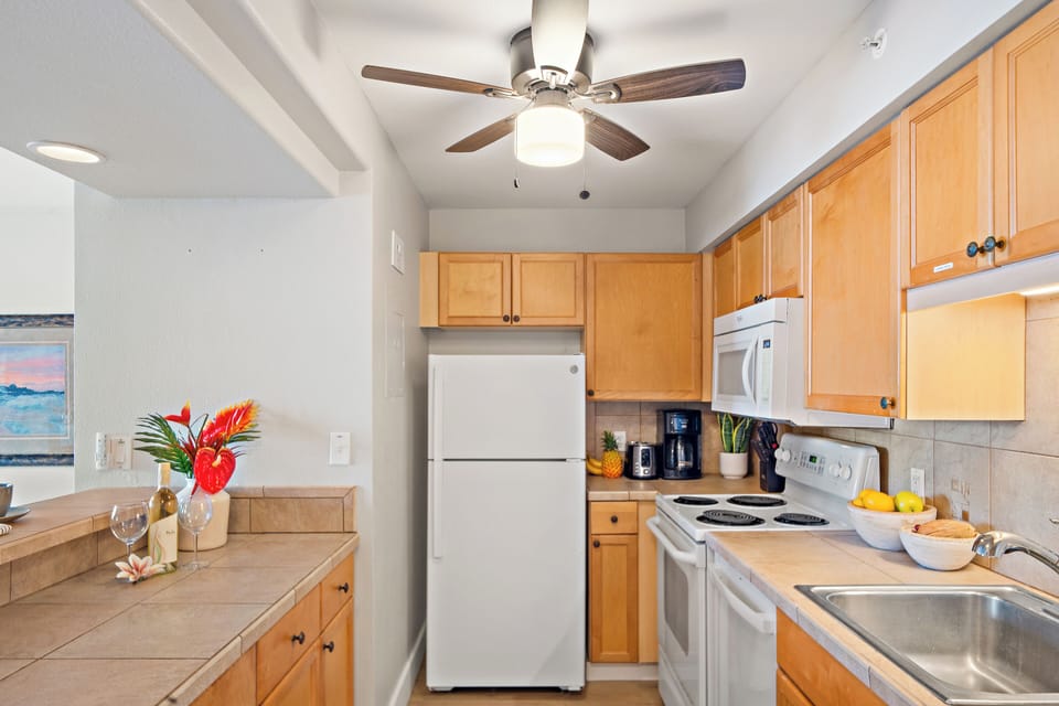 Kitchen with wooden cabinets and white appliances