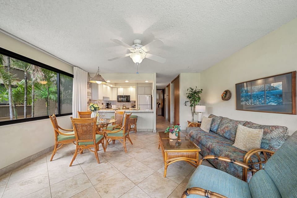 Spacious living area with tropical decor and natural light.