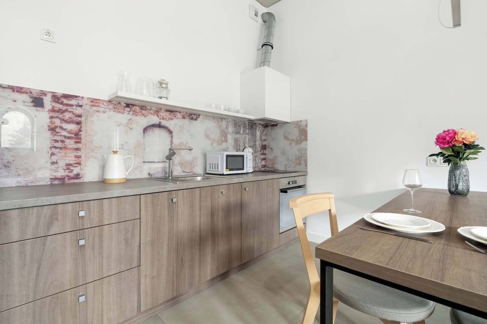 A view of the studio from the kitchenette side, showing the bed and dining area. The space is airy with plenty of natural light.