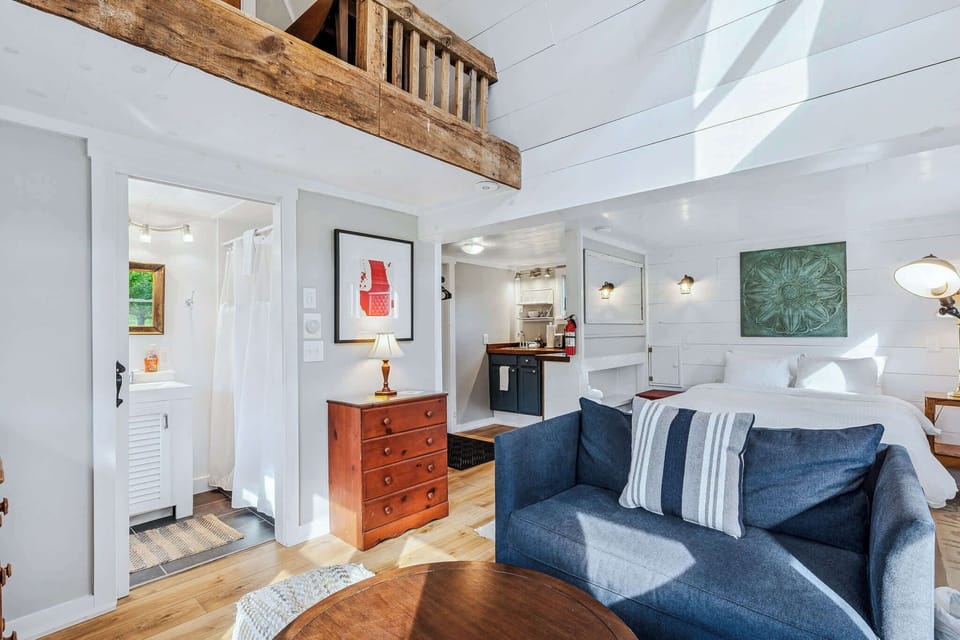 Full cottage layout: bathroom, loft, kitchenette, queen bed, and cozy living area