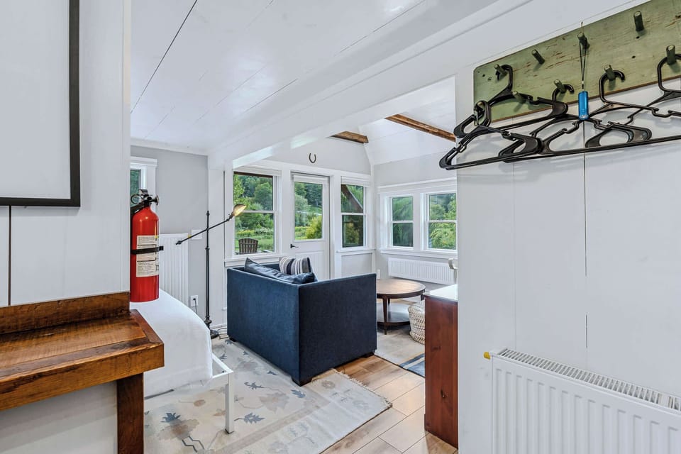 Cottage interior with original beams, coat hooks, and open floor plan