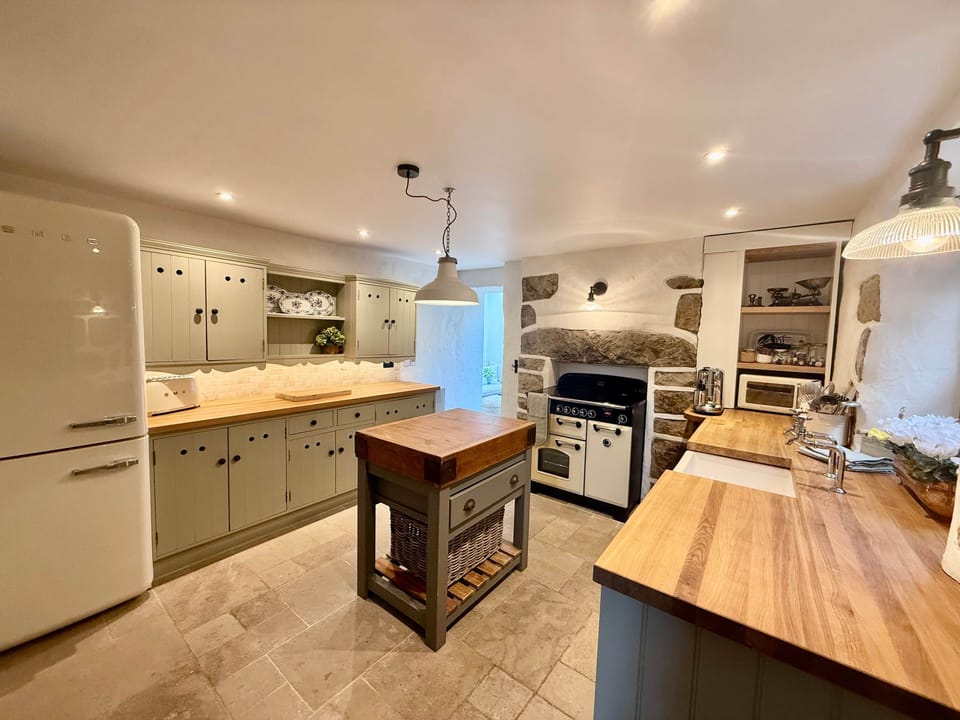 Traditional kitchen with butchers block and modern appliances in Arwel Cottage