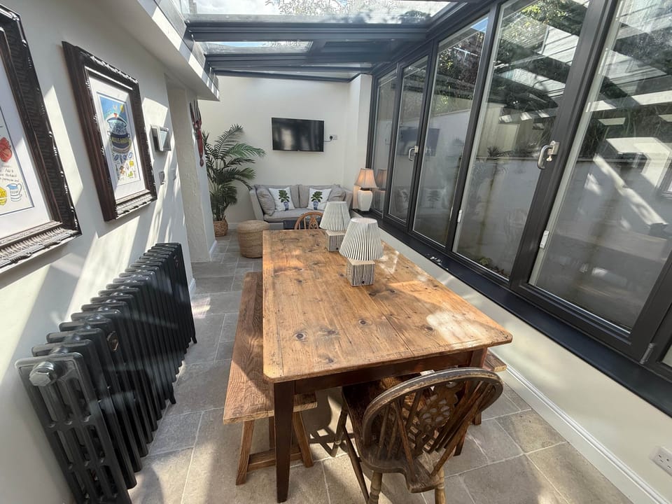 Spacious dining area with large rustic wooden table and vintage bifold doors