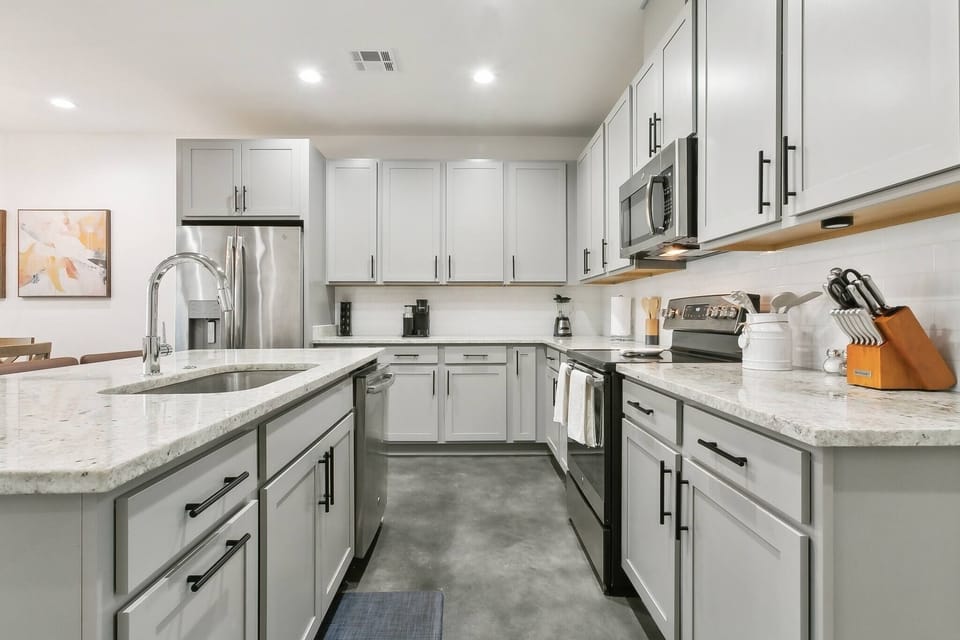 Beautifully designed kitchen with sleek granite countertops, stainless steel appliances, and abundant cabinetry — a bright and spacious setting for meal prep or entertaining.