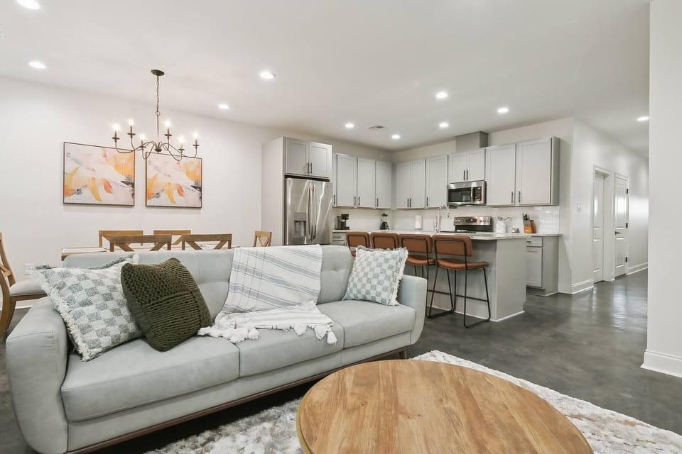 Open-concept living and dining area with cozy seating, Smart TV, and direct view of the fully equipped kitchen — perfect for families and groups.