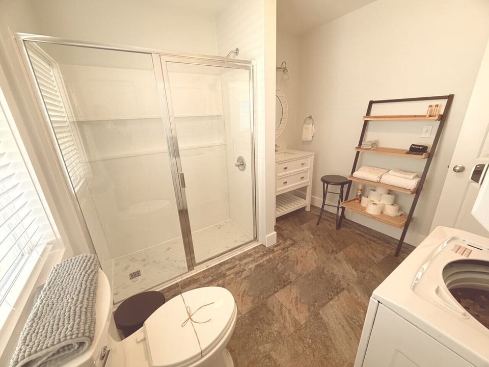 Large bathroom with stall shower, washer/dryer and closet.