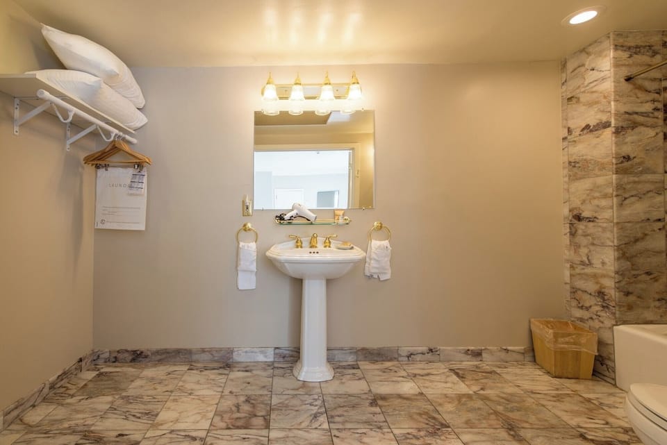 Stretch out and reset in an airy bath with marble accents.