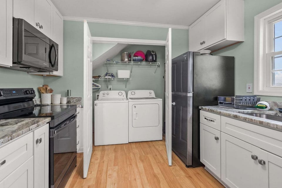 Full kitchen with white cabinets, a range and a window above the sink at Endless Summer in Cherry Grove