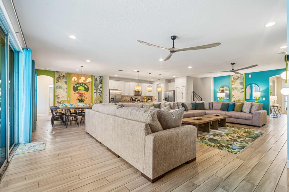 Open-concept living space w/ large sectional, natural light & seamless indoor-outdoor flow