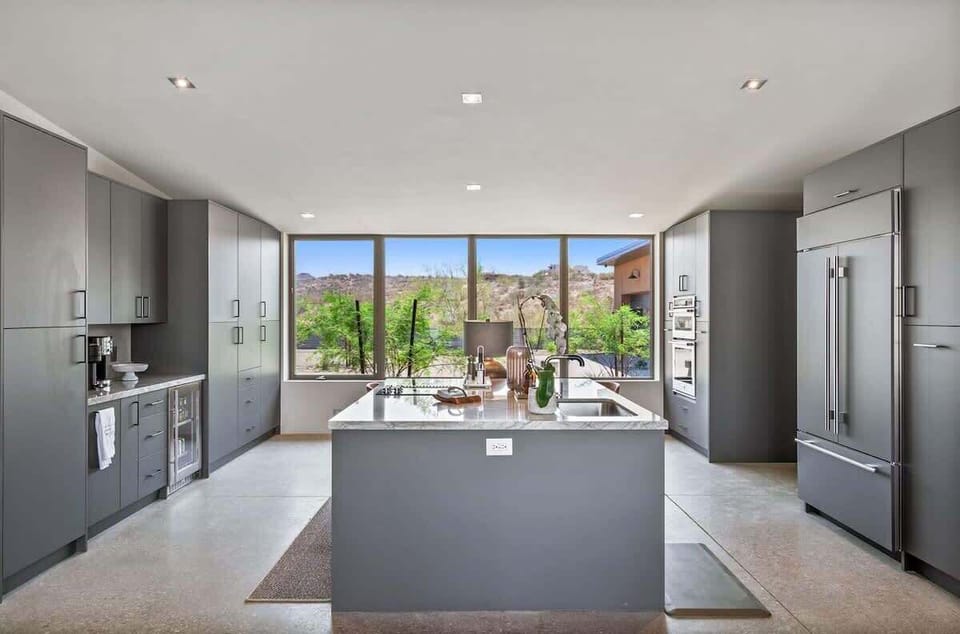 Estate 1 - Fully equipped luxury kitchen stocked with all culinary essentials and features high-end stainless-steel appliances, a kitchen island, a breakfast table, and a wet bar/coffee station.