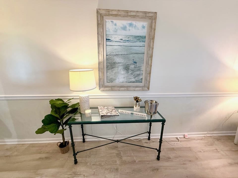 This charming console table with coastal art provides the perfect spot for dropping keys and adding a touch of elegance.