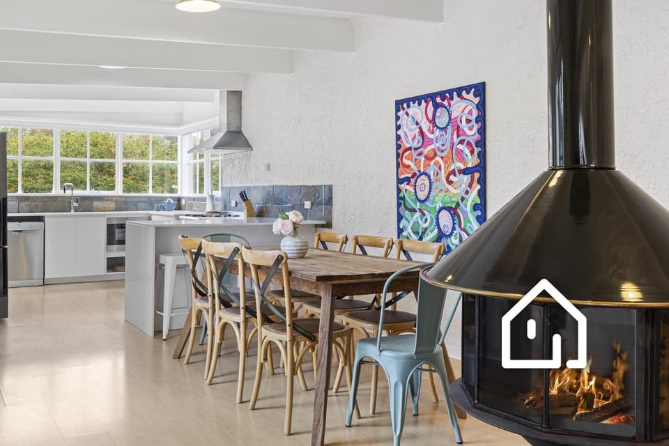 The dining area sits between the kitchen and fireplace/main living area