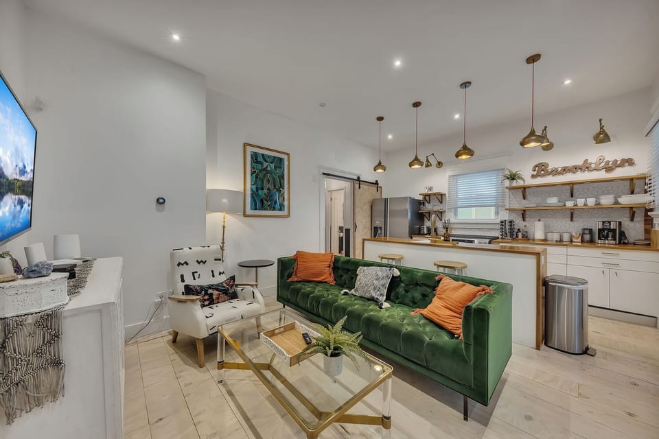 Open-concept lounge flows into kitchen w/ bar seating & warm pendant lighting
