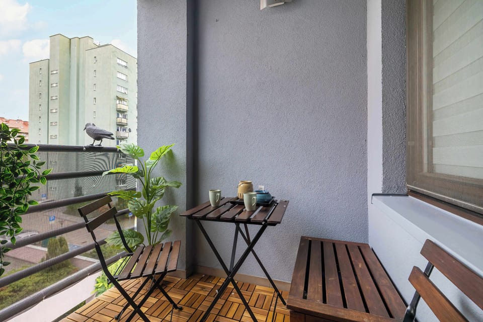 The balcony with wooden flooring and a coffee table lets you enjoy fresh air and your morning coffee outdoors.