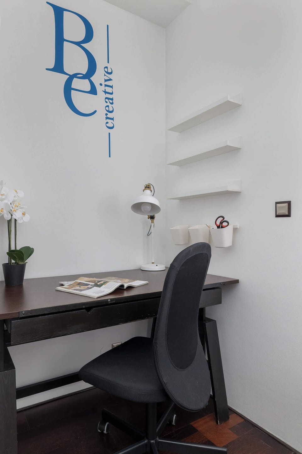 A practical desk with an ergonomic chair provides a comfortable spot for remote work or study.