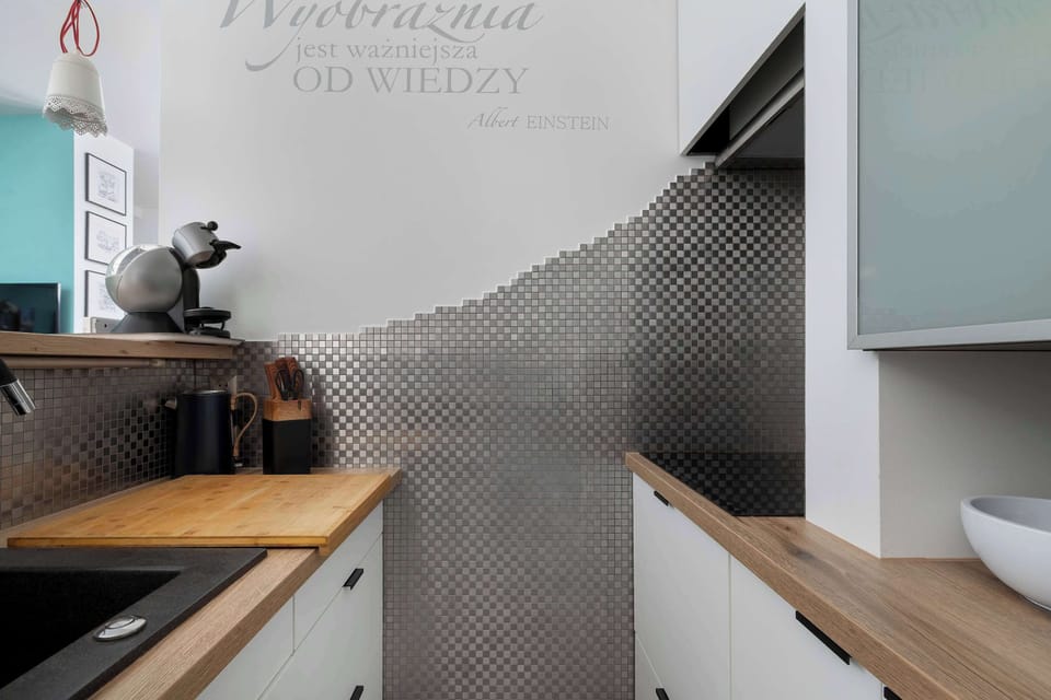 The kitchen with wooden countertops and designer tiles blends modern style with functionality.