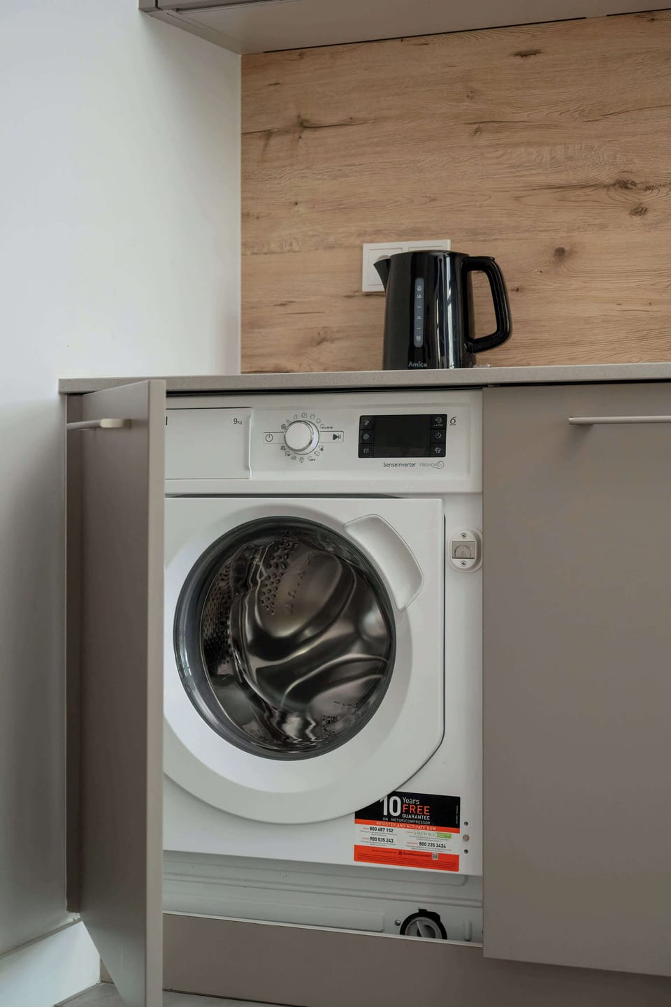 A washing machine tucked neatly into a kitchen cabinet.