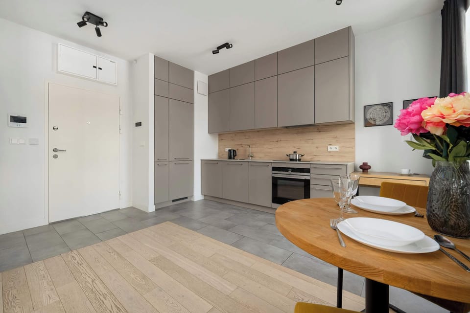An open-plan layout combining a kitchenette, dining table, and entrance hallway.