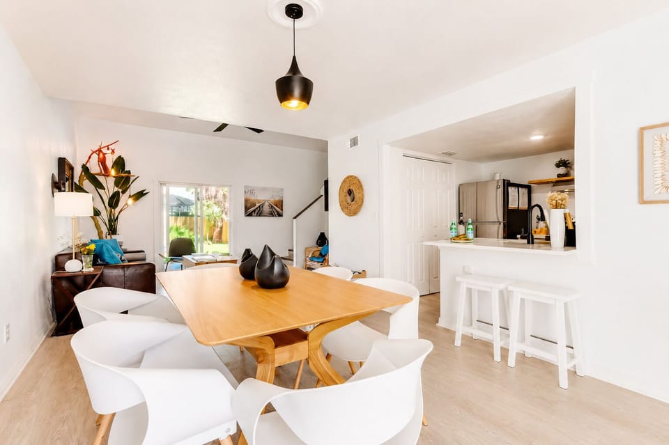 Bright open dining area with modern kitchen bar and backyard views