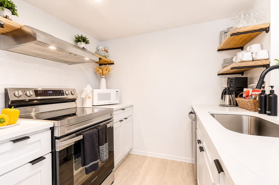 Bright modern kitchen with stainless appliances and stylish open shelving