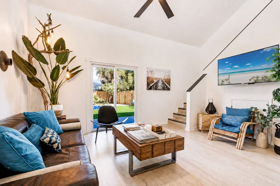 Bright coastal living room with vaulted ceilings and backyard access