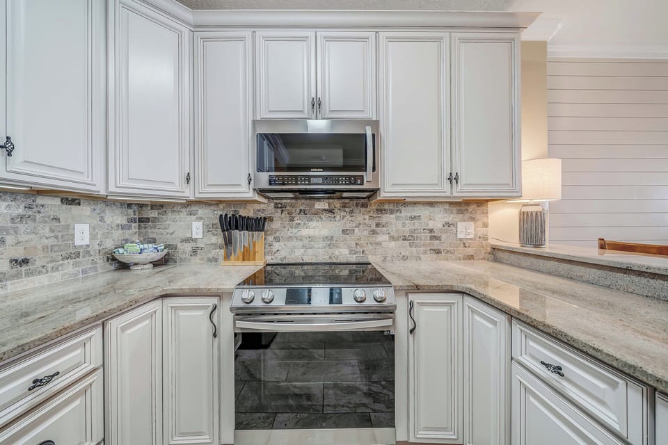The beautifully updated and fully equipped kitchen features granite countertops, stainless-steel appliances, and has everything you need to prepare meals for family & friends.