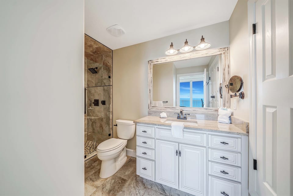 The ensuite master bathroom features granite countertops and a beautifully tiled walk-in shower.