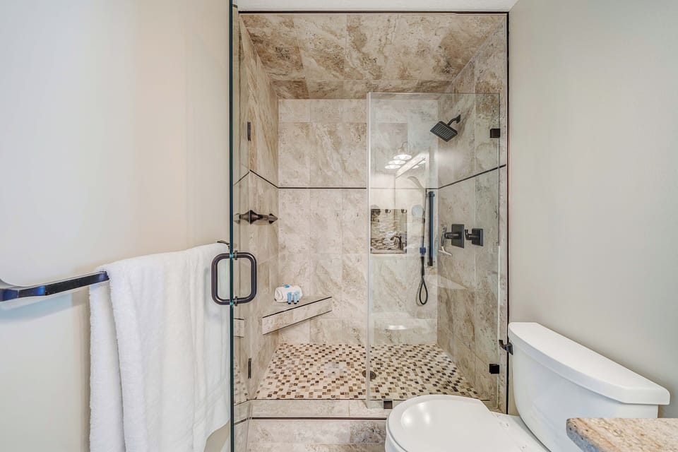 The ensuite master bathroom features granite countertops and a beautifully tiled walk-in shower.