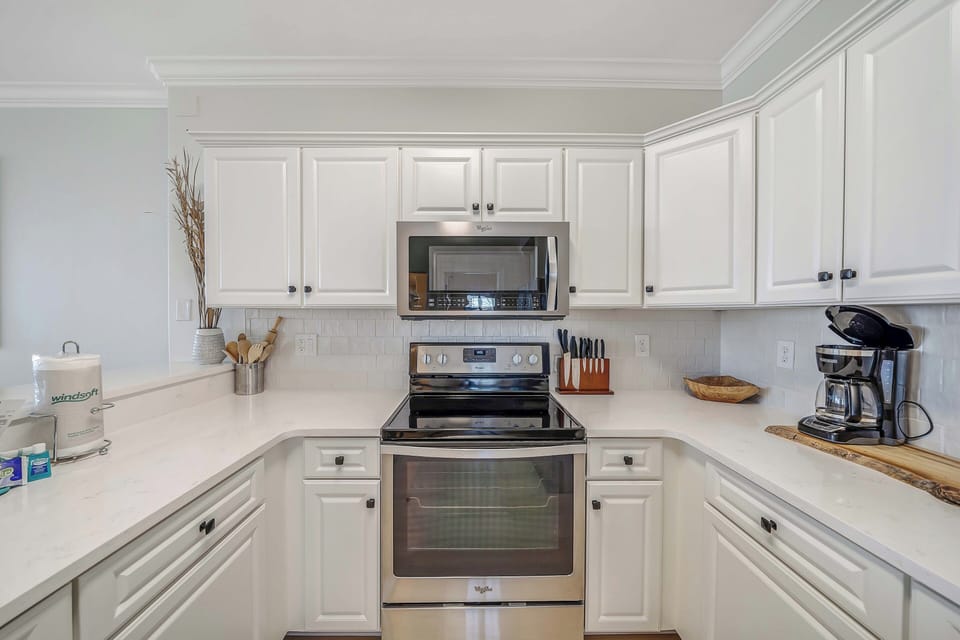The fully equipped kitchen features quartz countertops, stainless-steel appliances, and has everything you need to prepare meals for family & friends.