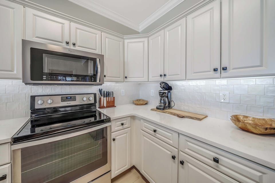 The fully equipped kitchen features quartz countertops, stainless-steel appliances, and has everything you need to prepare meals for family & friends.