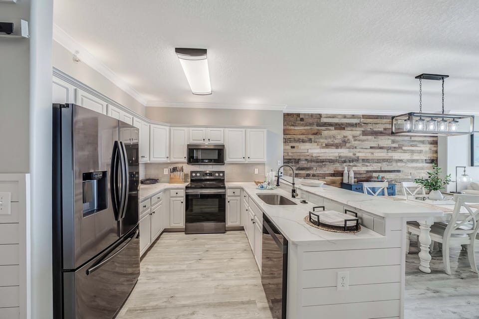 The fully equipped kitchen features quartz countertops, stainless-steel appliances, and has everything you need to prepare meals for family & friends.