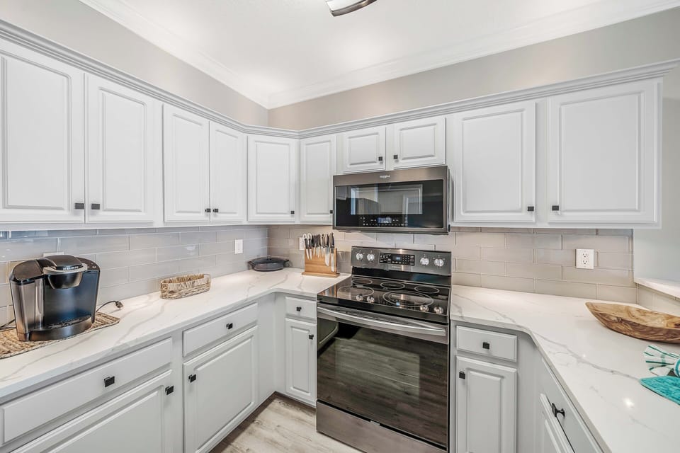 The fully equipped kitchen features quartz countertops, stainless-steel appliances, and has everything you need to prepare meals for family & friends.