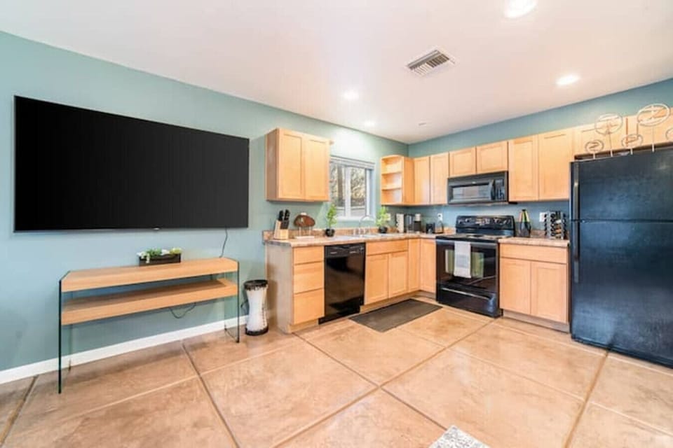 Large 75` smart TV next to the bright kitchen with lovely window over the sink, perfect for morning coffee prep