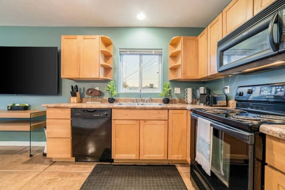 Fully equipped kitchen with ample storage, modern appliances, and natural light