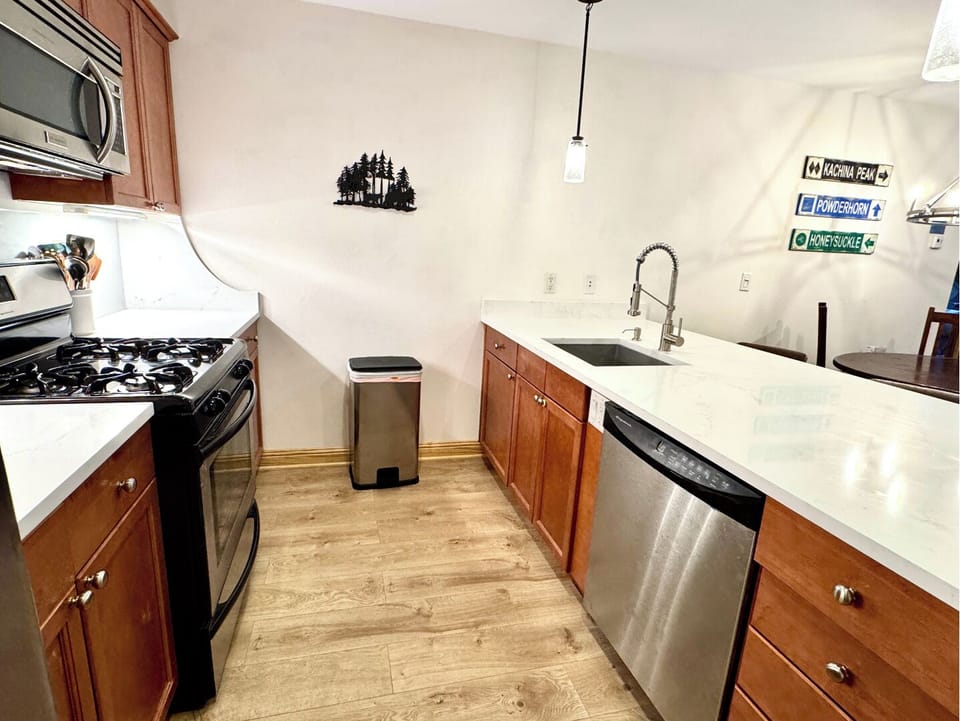 Your fully equipped kitchen features stainless steel appliances, granite countertops, and warm wood cabinetry—perfect for preparing meals and enjoying quality time together during your mountain getaway.