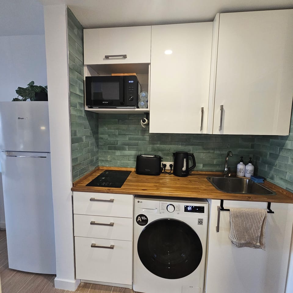 Kitchenette with washing machine, hob, kettle, toaster and fridge freezer