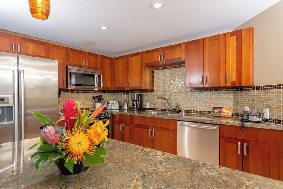Chef-ready kitchen with granite countertops, stainless appliances, and a floral island welcome centerpiece HKH-423