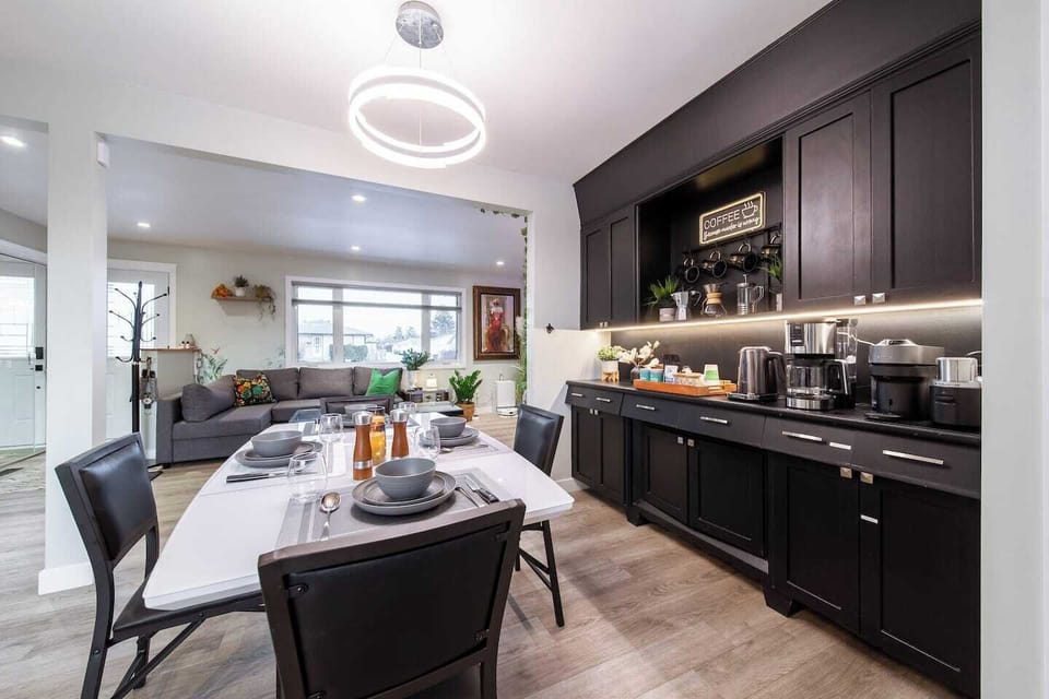 A space made for togetherness, where meals and moments come easily. Modern lighting and dark cabinetry add a touch of sophistication.