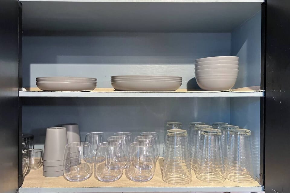 Thoughtfully stocked with matching dishware and glassware, this cabinet keeps everything neat and ready for your next meal.