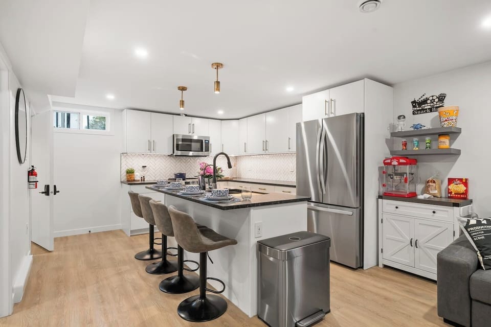 Sleek, modern kitchen with everything you need, from stainless steel appliances to a cozy breakfast bar and even a fun snack station!
