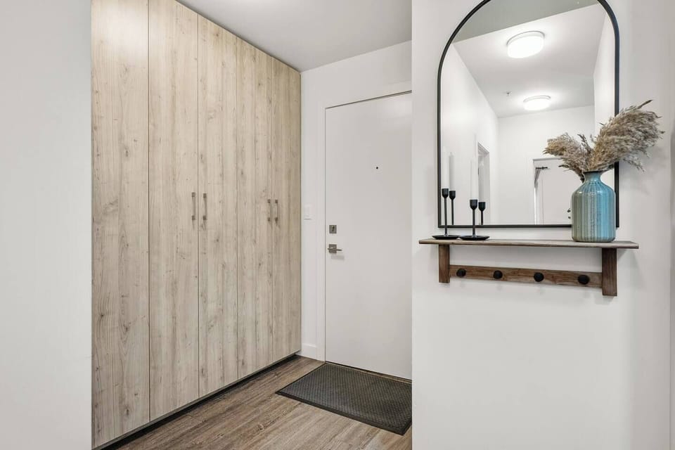 Step into a calming space where natural textures meet modern style. This thoughtfully designed entryway offers generous storage, warm wood tones, and a cozy mirror nook to drop your keys and ease into your stay.