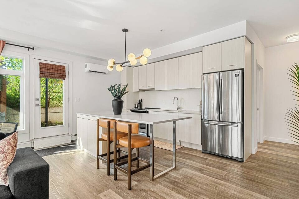 A bright and modern kitchen featuring sleek cabinetry, stainless steel appliances, and a spacious island perfect for casual dining or entertaining.